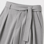 Grey men's wide-leg pleated trousers waistband and pleat detail
